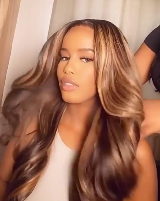 Long curly human hair wig with big loose waves in brown, styled on a woman — available in sizes 8 to 20 inches